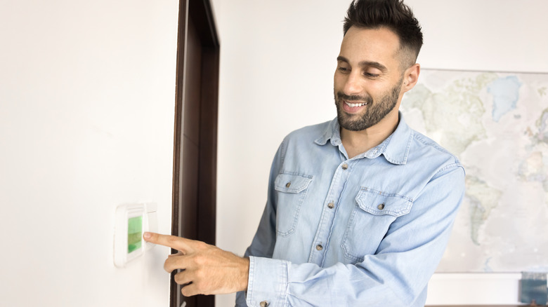 person adjusting thermostat