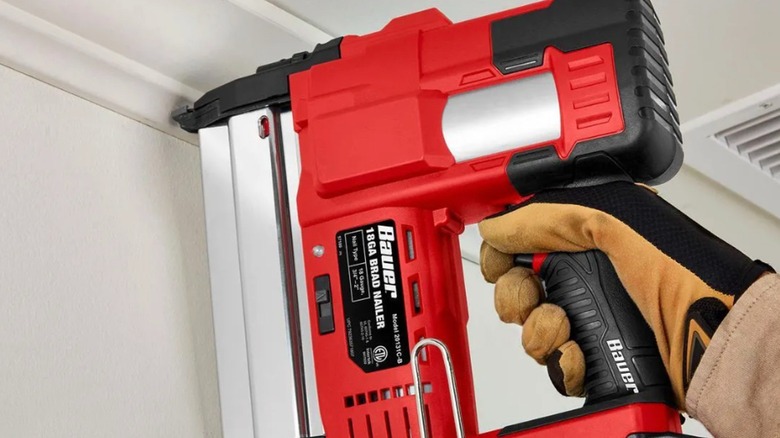 Worker nailing trim with a cordless brad nailer