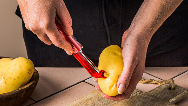 The Dreamfarm Sharple Vegetable Peeler being used to peel a potato.