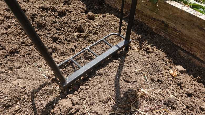 A broadfork used within the confines of a raised garden bed