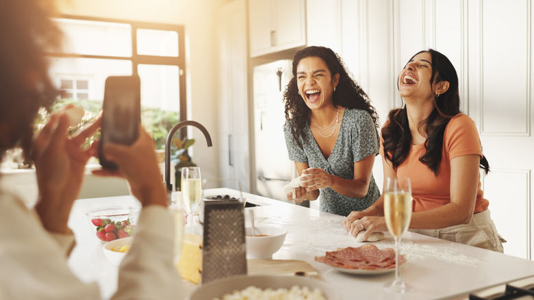 Friends laughing as they cook together