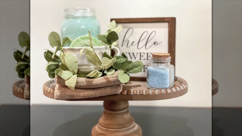Bathroom handtowels and salts sit on a wooden cakestand
