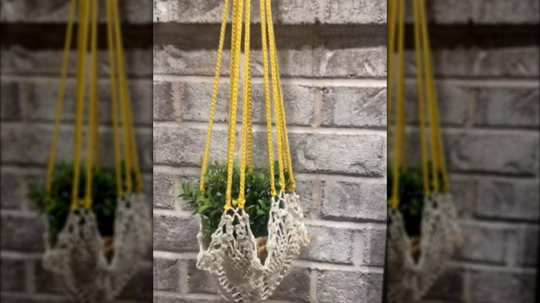 DIY plant hanger made with an old doily and yellow yarn