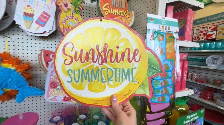 a hand holding lemon-themed summer wall decor