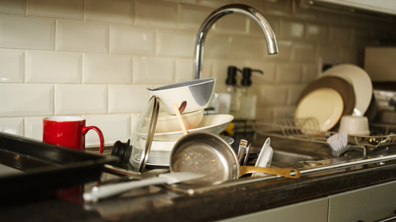 A kitchen sink is full of dirty dishes