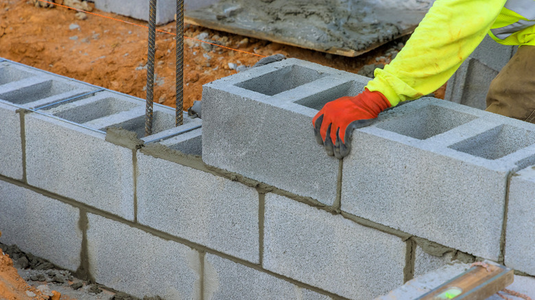 a construction worker building a concrete block wall