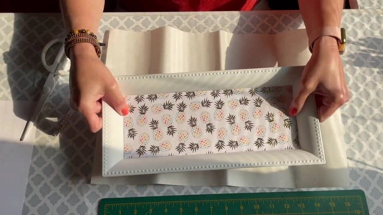 Creator holding up her decorated Dollar Tree charger tray