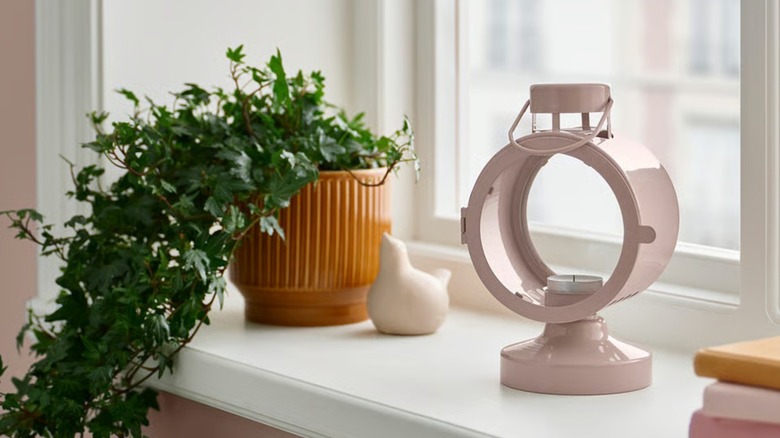 A pink lantern-style FLODSVALA lantern with a tea light inside