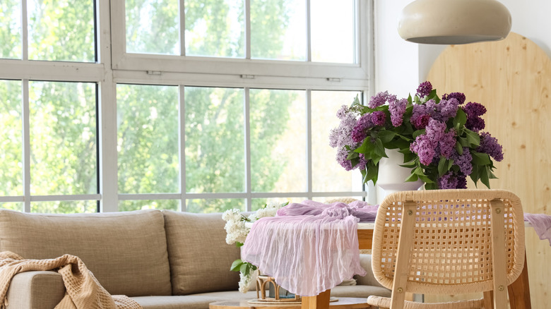 Kitchen table with a vase full of purple lilacs