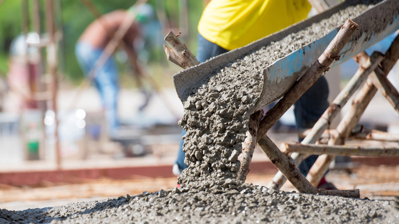 Workers pouring concrete for building foundation