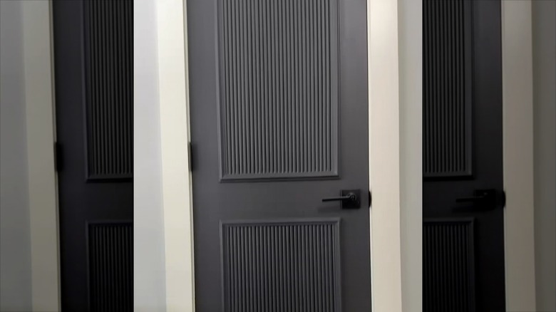 A black door with fluted panels