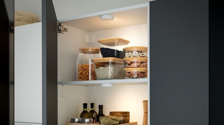 Two small GÖMPYSSLING LED lights inside a kitchen cabinet