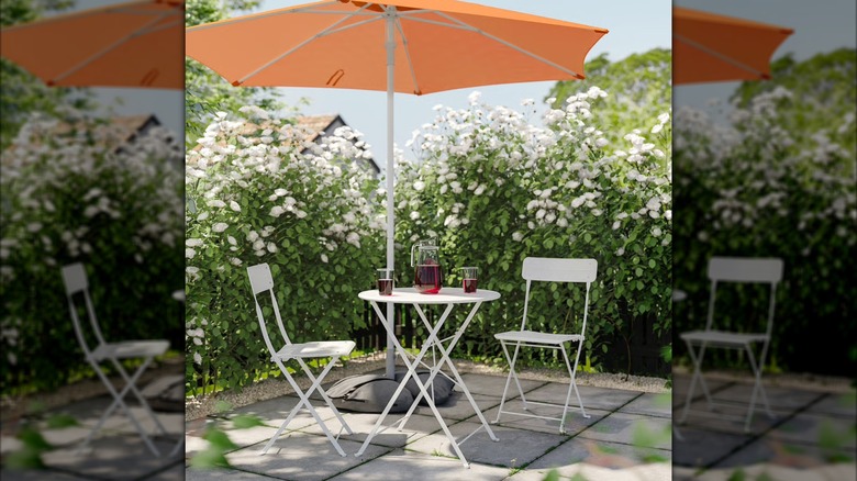 IKEA's HÖGÖN / IGGÖN umbrella in orange above a wooden dining set