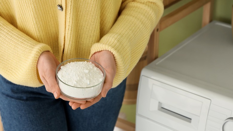 Woman holding bowl full of powdered laundry detergent
