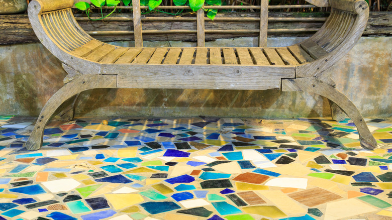 Wooden bench on mosaic tile patio