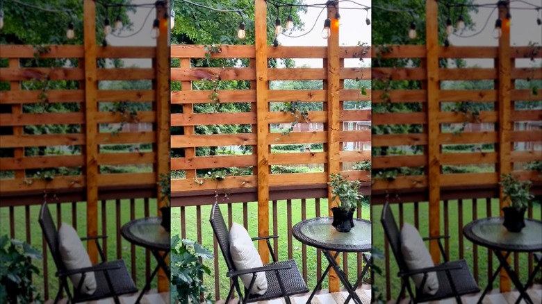 DIY wood pallet privacy screen over a backyard porch railing