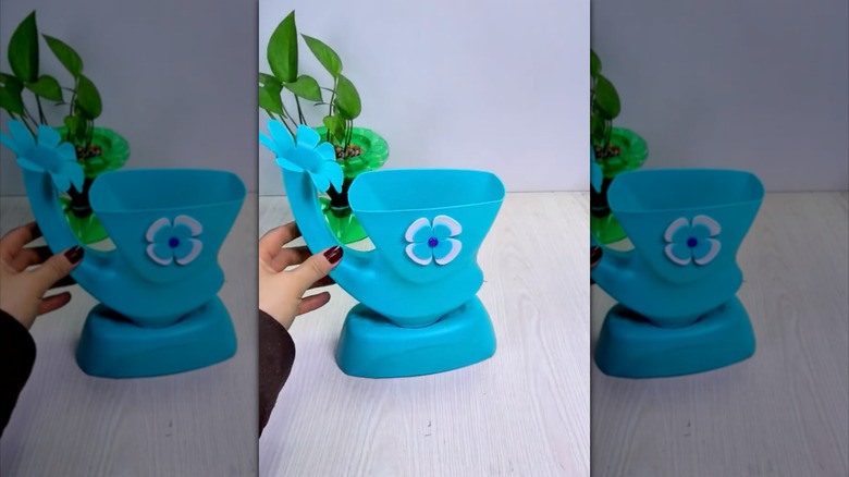 hand holding DIY laundry detergent bottle flower pot