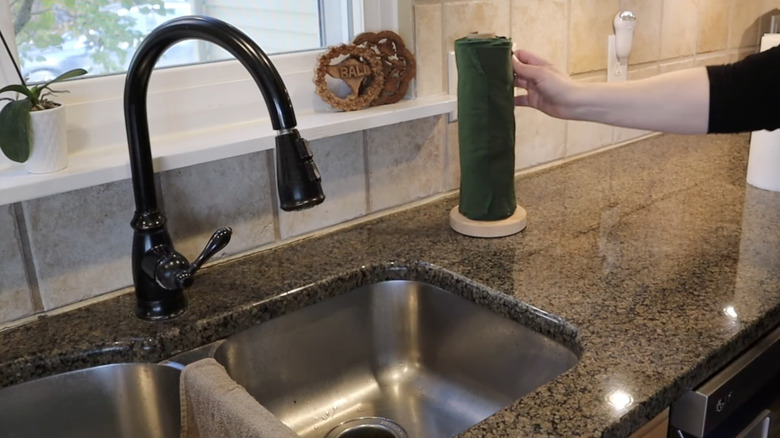 A handing reaching for reusable fabric towel roll