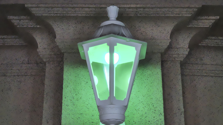 Green light bulb in lantern on a front porch