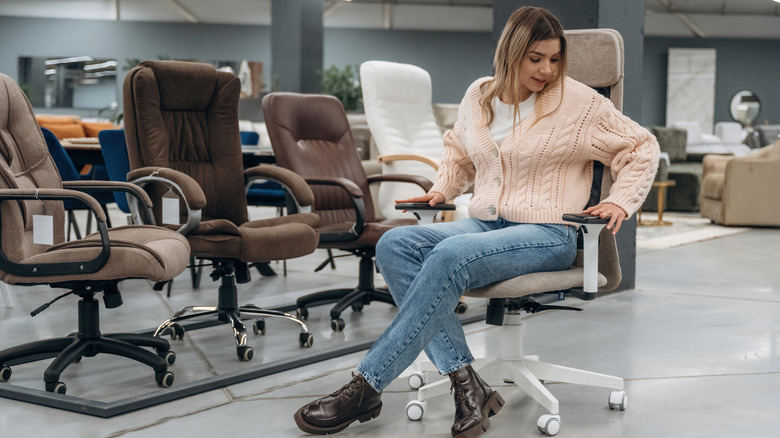Woman inspecting a swivel chair in a store