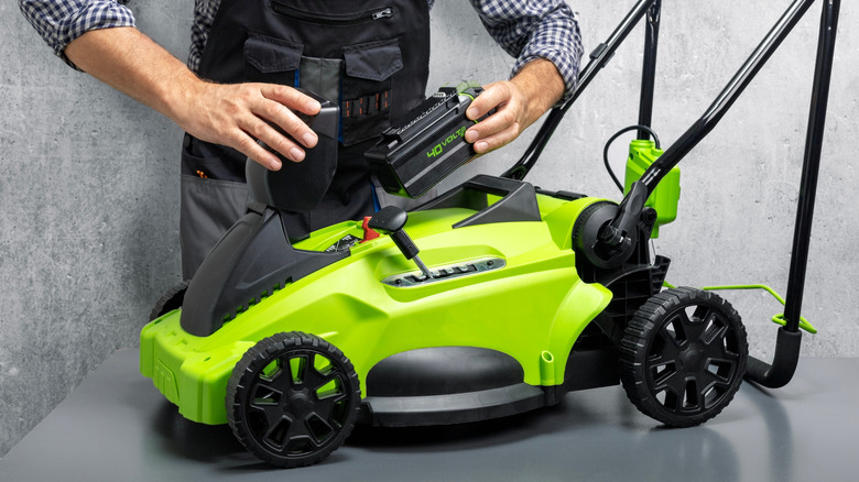 Putting a battery in an electric mower on a work table