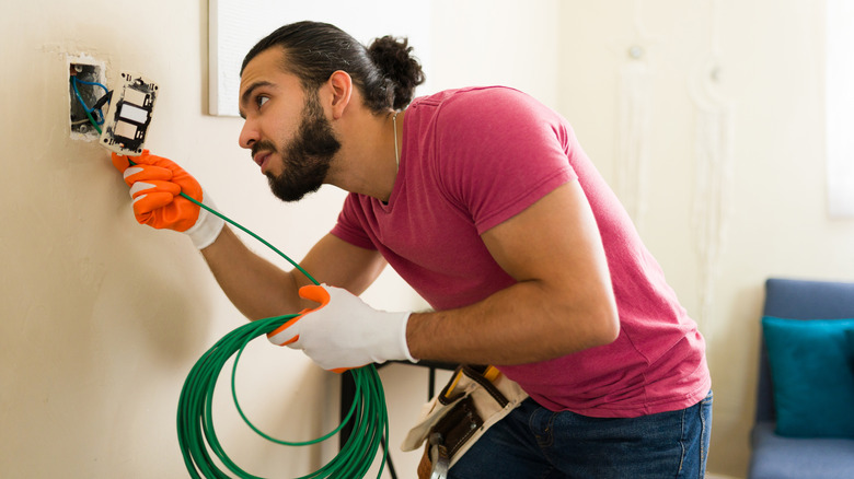 Professional electrician installing outlet