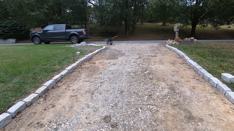 A gravel driveway lines with Belgian blocks