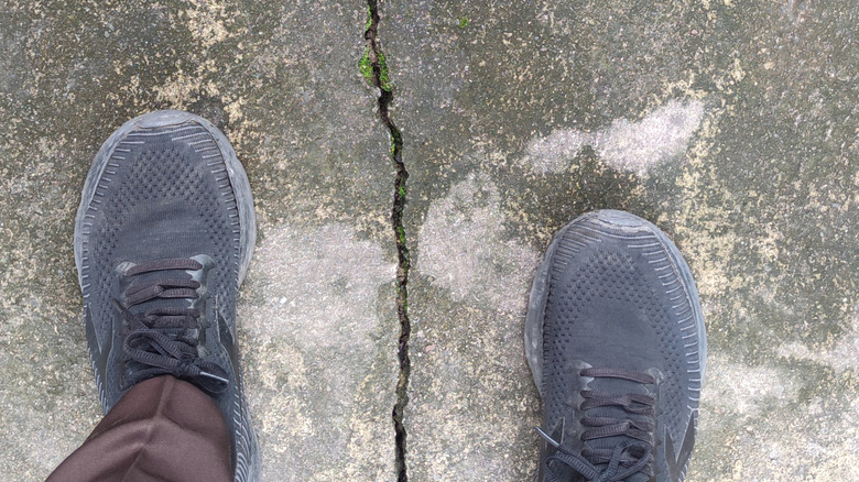 Cracked concrete floor under feet
