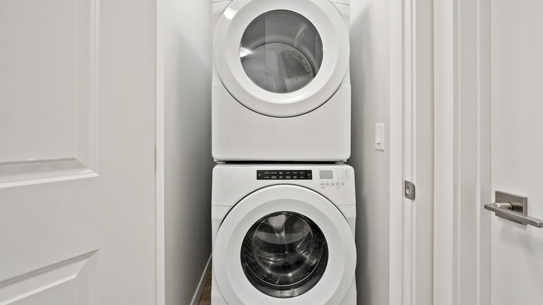 stacked white washer and dryer set in small space
