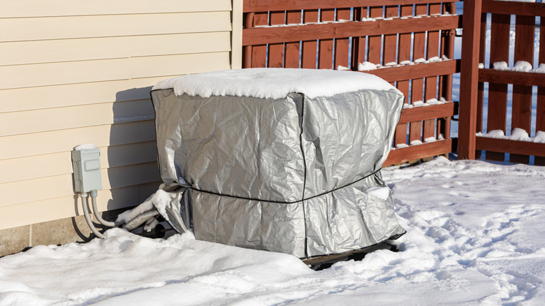 an AC condenser unit covered with clear plastic