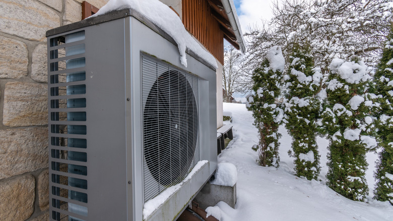 Heat pump in winter against a house