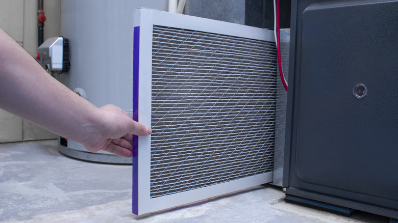 Person replacing furnace filter