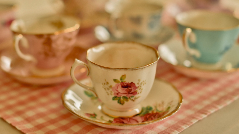 Teacups and saucers on plaid tablecloth