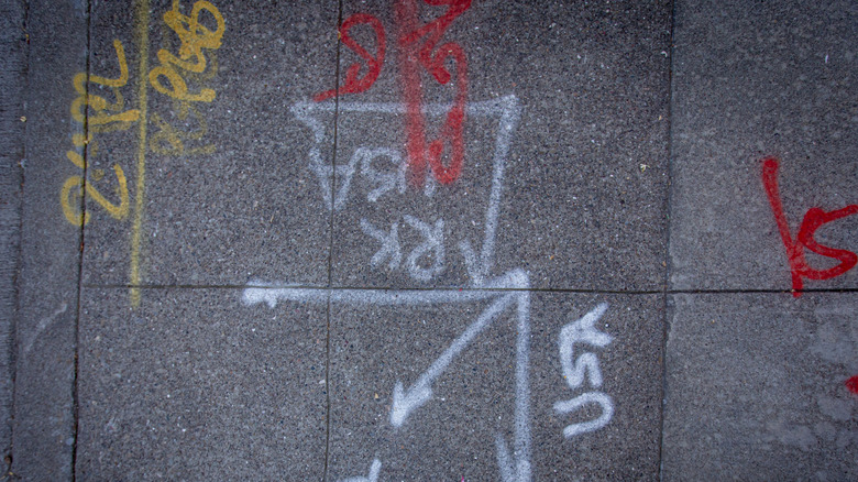 White, red, and yellow utility markings on stone pavers