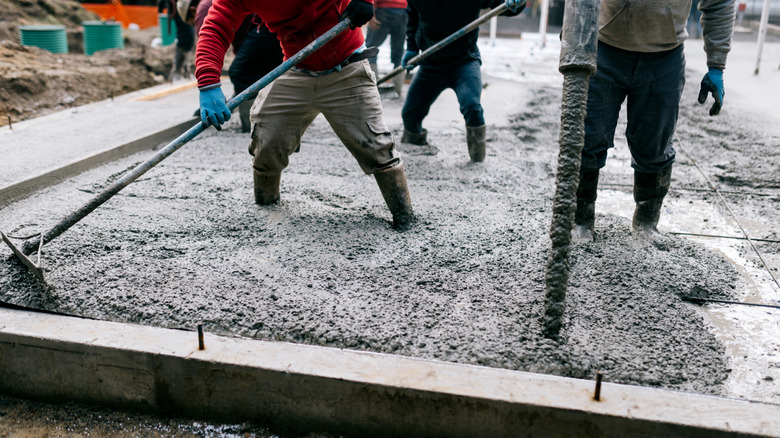 Team of men pouring concrete