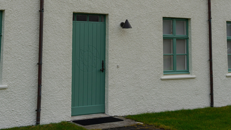 Close-up of an angular house, featuring a green door