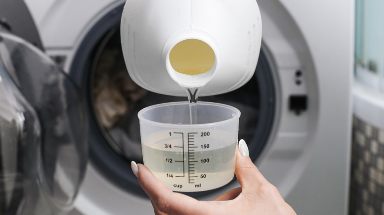 Woman pouring laundry detergent into the lid