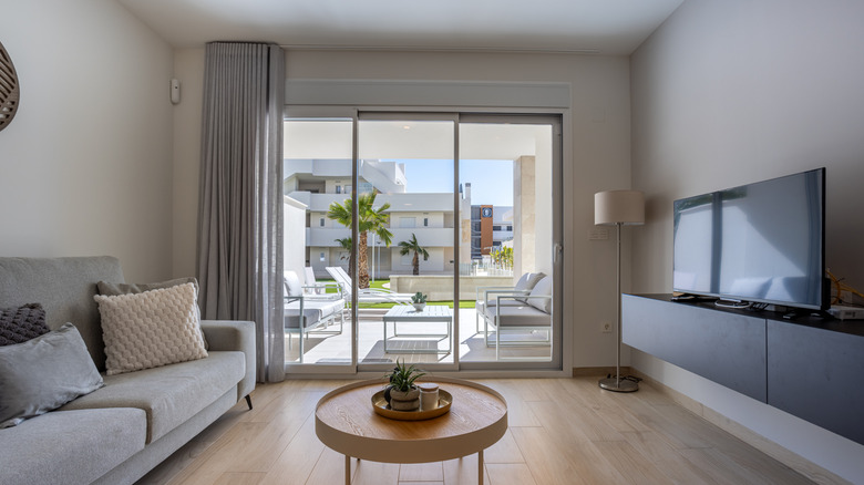 A living room with white basic sliding glass door to the exterior