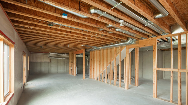Exposed joists and mechanical fixtures in a basement ceiling