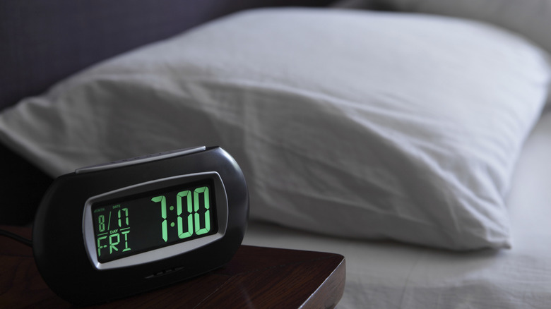 Close up of a digital clock on a nightstand showing 