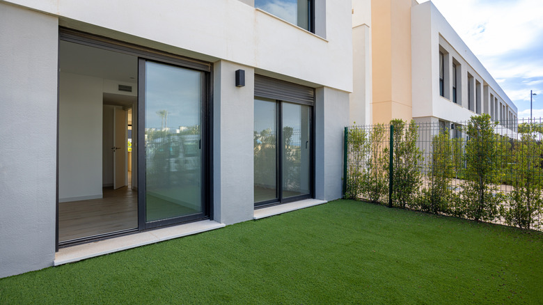 View of the back of a house and its sliding glass door from the garden