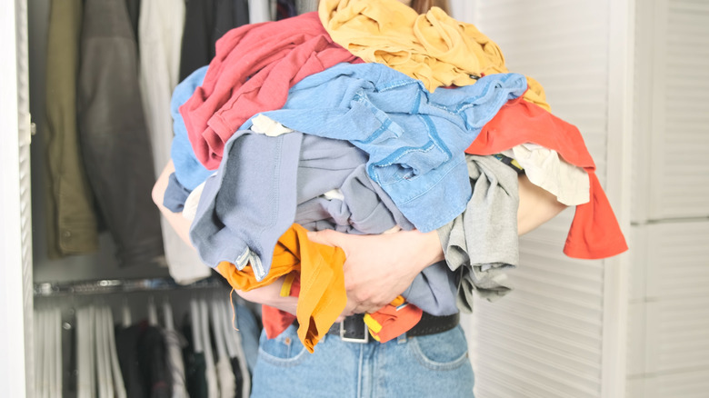 Woman holding big pile of clothing