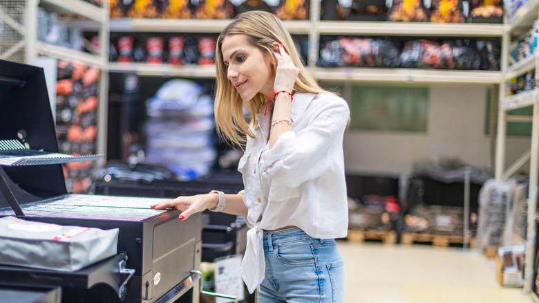 A woman shops for grills