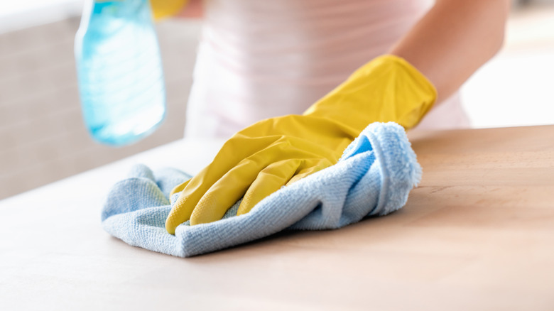 hand holding dry blue soft microfiber rag and wiping surface