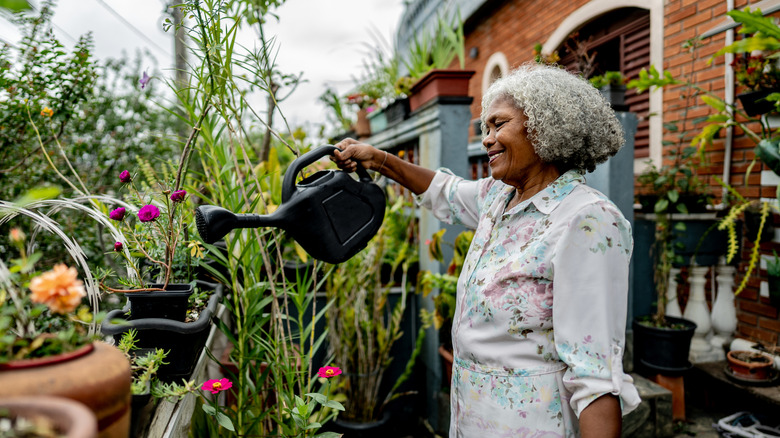 Older woman watering plants