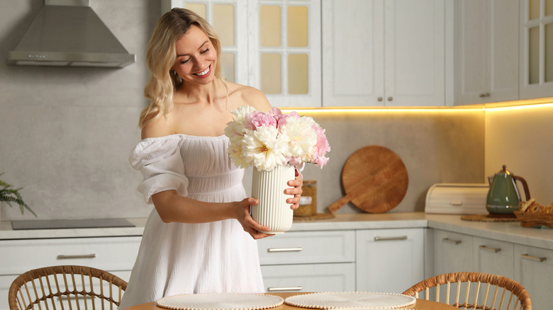 a woman holding vase of flowers
