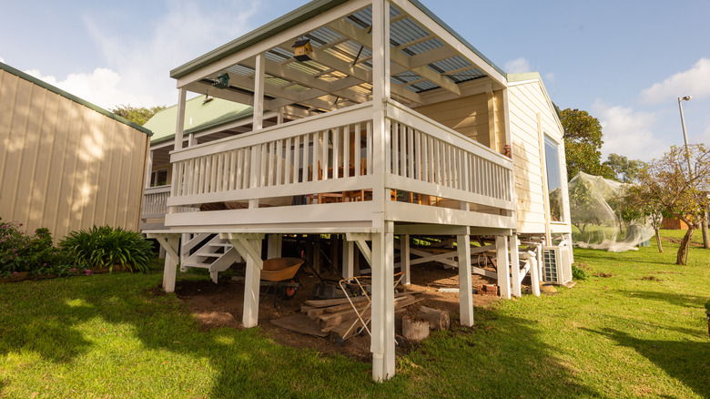 A wooden deck with items stored under it