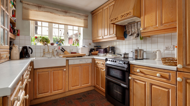 Honey oak kitchen cabinets on a white tile backsplash
