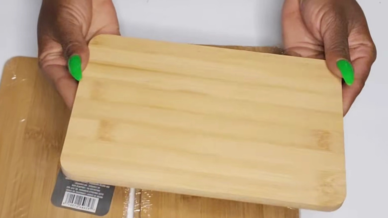 Hands with painted green nails holding cutting board from Dollar Tree
