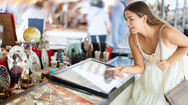 A woman points at an antique decor piece